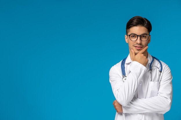 Doctors Day hübscher brünetter süßer Typ im Arztkittel, der denkt und eine Brille trägt