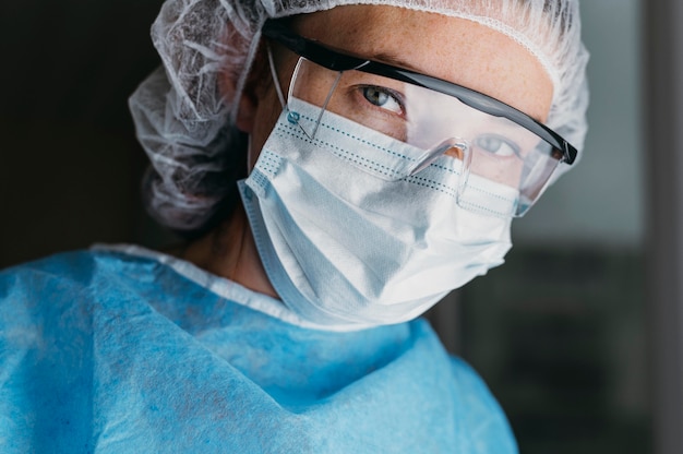 Kostenloses Foto doktor, der eine gesichtsmaske und eine schutzbrille trägt