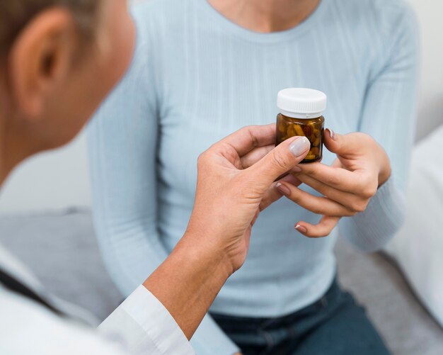 Doktor, der einem Patienten eine Flasche Pillen gibt