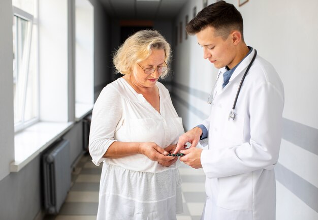 Doktor, der geduldige Pillen für Behandlung zeigt