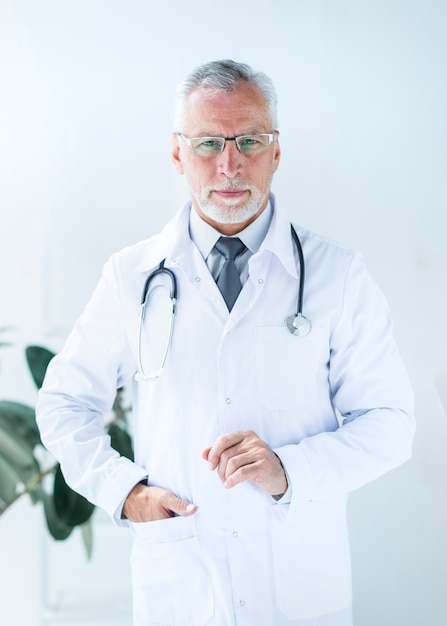 Doktor, der Hand in der Tasche im Büro hält