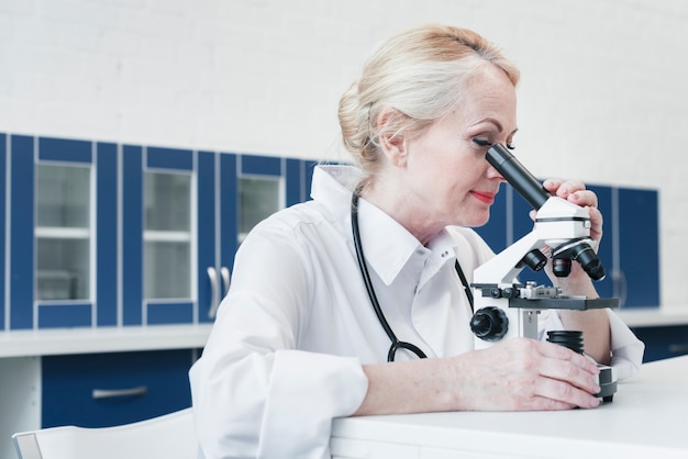 Doktor, der mit einem Mikroskop analysiert