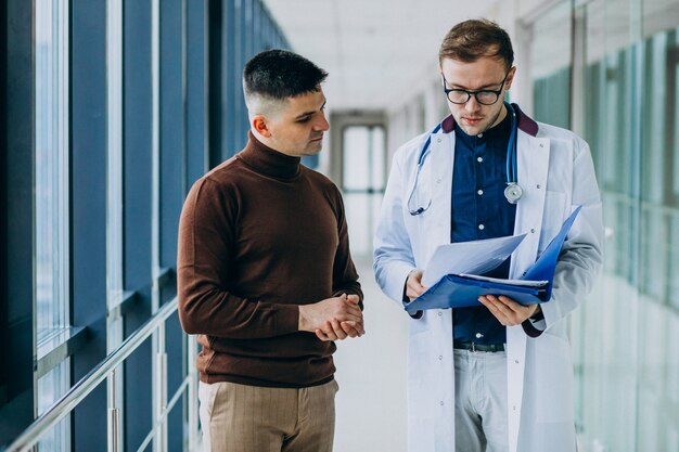 Doktor, der mit seinem Patienten an der Klinik spricht