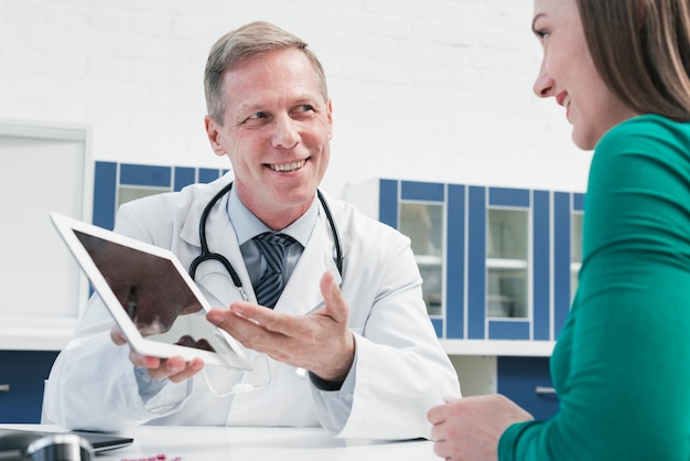 Doktor, der zu einem Patienten neigt