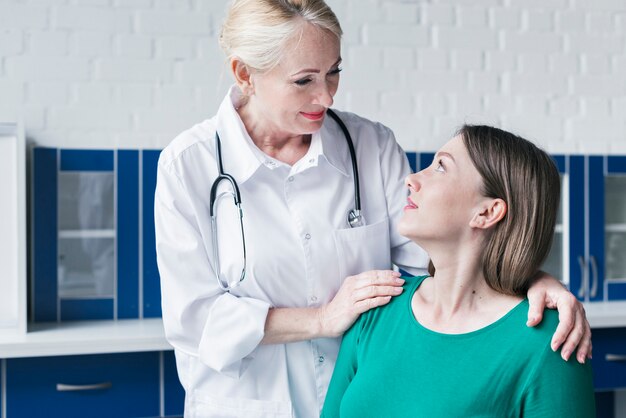 Doktor, der zu einem Patienten neigt