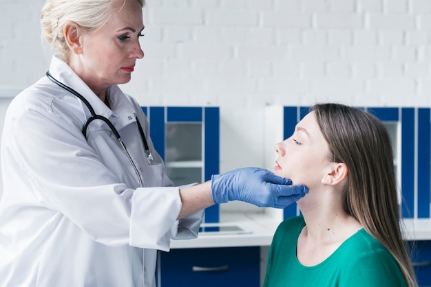 Doktor, der zu einem Patienten neigt