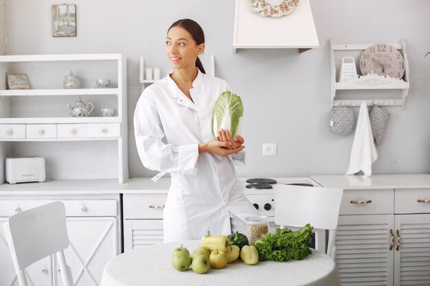 Doktor in einer Küche mit Gemüse