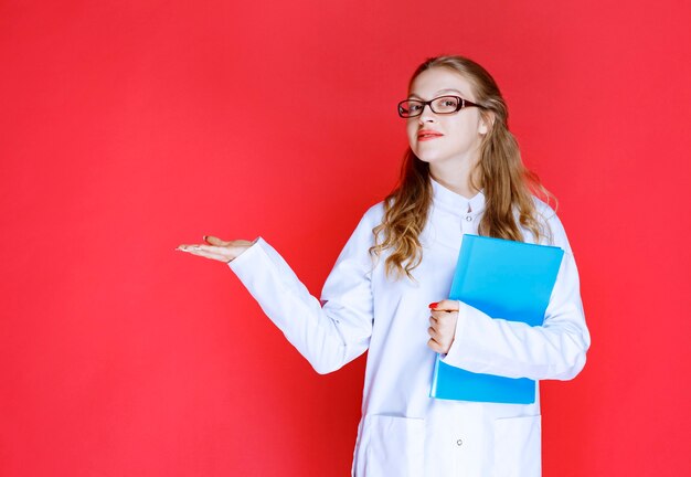 Doktor mit Brille, die einen Unschärfeordner hält.