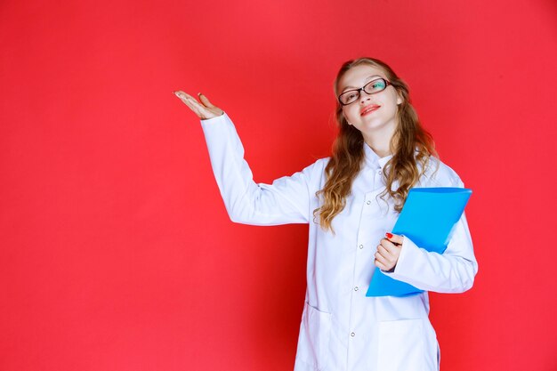 Doktor mit einem blauen Ordner, der nach links zeigt.