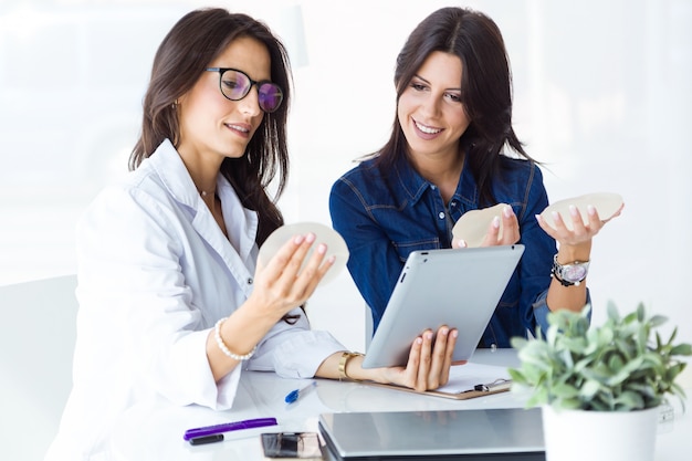 Doktor und ihr Patient, die Brustprothese im Büro wählen.