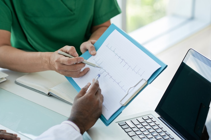 Kostenlose Foto doktoren, die kardiogramm ihres patienten betrachten