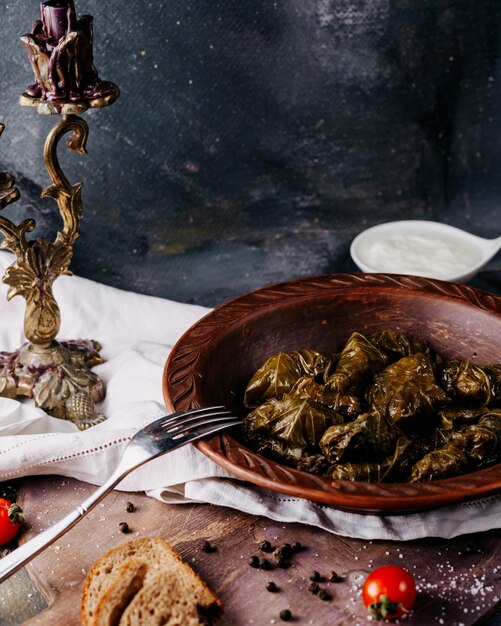 Dolma leckeres gesalzenes Fleischmehl in braunem Teller auf der dunklen Oberfläche