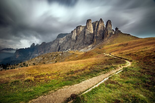 Dolomiten in Südtirol, umgeben von Grün unter dem bewölkten Himmel in Italien