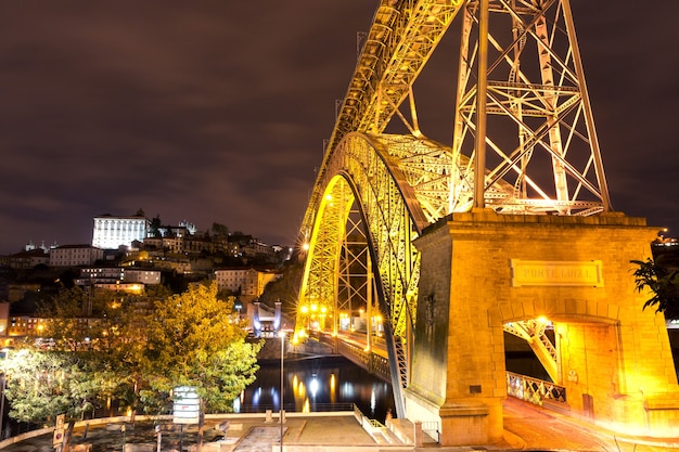 Dom luis i oder luiz i eisenbogenbrücke über den fluss douro mit reflexion und kloster serra von pilar in porto bei nacht, portugal.