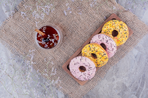 Donut brötchen auf einer holzplatte mit einer tasse glitzern