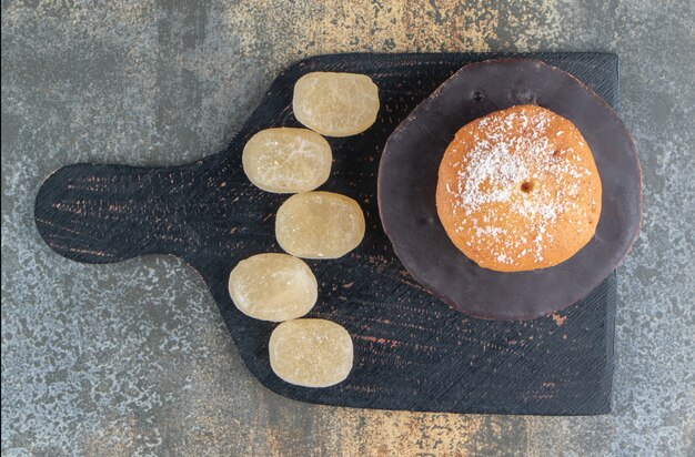 Donut mit Zuckerpulver und süßen Bonbons belegt