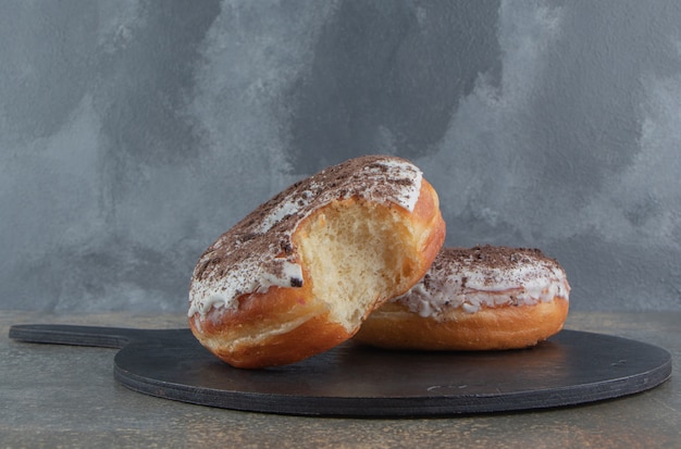 Donuts auf einem schwarzen holzbrett