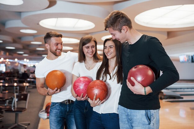 Doppeldate. Junge fröhliche Freunde haben an ihren Wochenenden Spaß im Bowlingclub