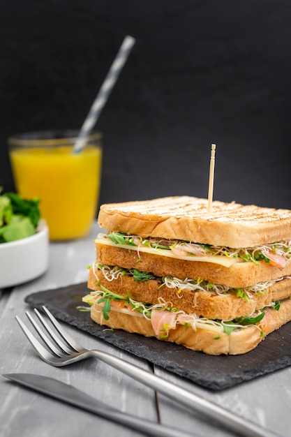 Kostenloses Foto doppelsandwich auf schiefer mit besteck