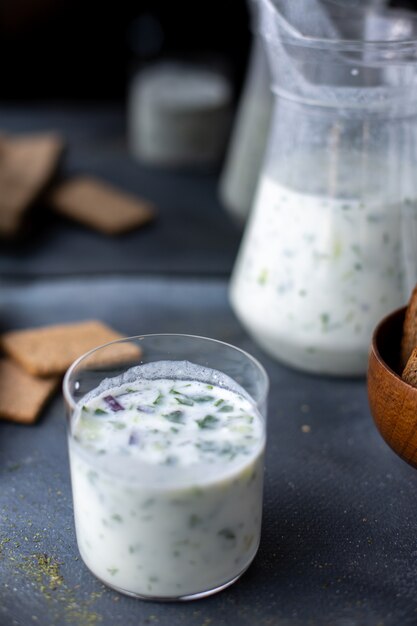 Dovga Greens Dovga in einem kleinen Glas zusammen mit Chips auf grauem Schreibtisch