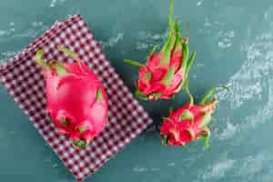 Kostenloses Foto drachenfrucht auf gips und picknicktuch. draufsicht.