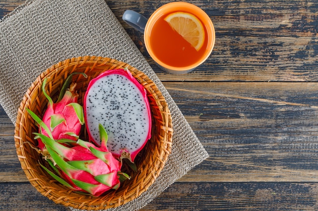 Drachenfrucht in einem Korb mit Tee Draufsicht auf Holztisch