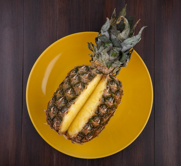 Draufsicht auf Ananas in Platte auf Holzoberfläche
