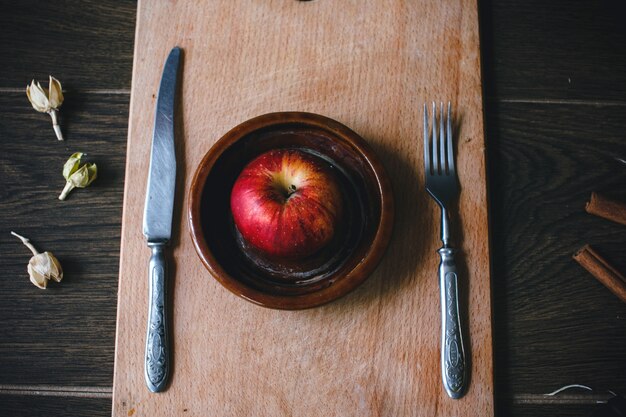 Draufsicht auf Apfel zwischen einem Messer und einer Gabel