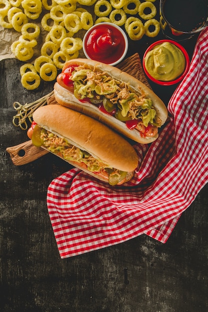 Draufsicht auf appetitliche Hot Dogs und Zwiebelringe