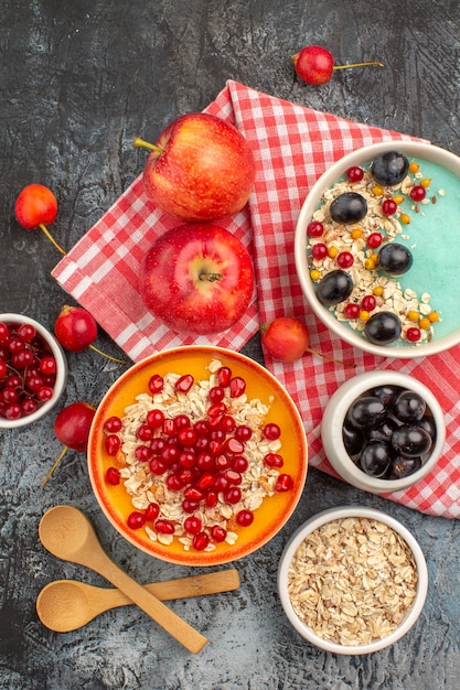 Draufsicht auf beerenlöffel äpfel bunte beeren haferflocken granatapfel