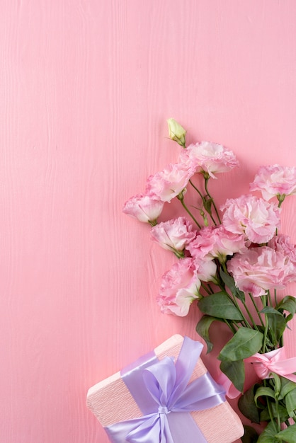 Kostenloses Foto draufsicht auf blumenstrauß mit geschenk