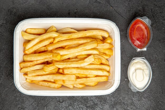 Draufsicht auf Bratkartoffeln mit Kartoffeln, serviert mit Ketchup und Mayonnaise