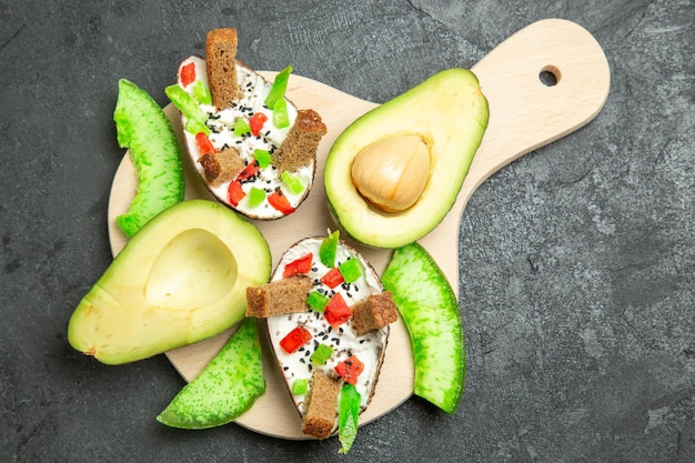 Kostenloses Foto draufsicht auf cremige avocados mit brot und pfeffer und frischen avocados auf der grauen oberfläche