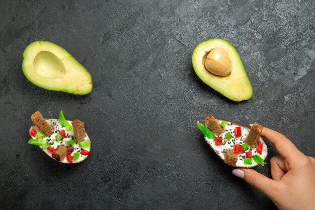 Draufsicht auf cremige Avocados mit frischen Avocados auf grauer Oberfläche