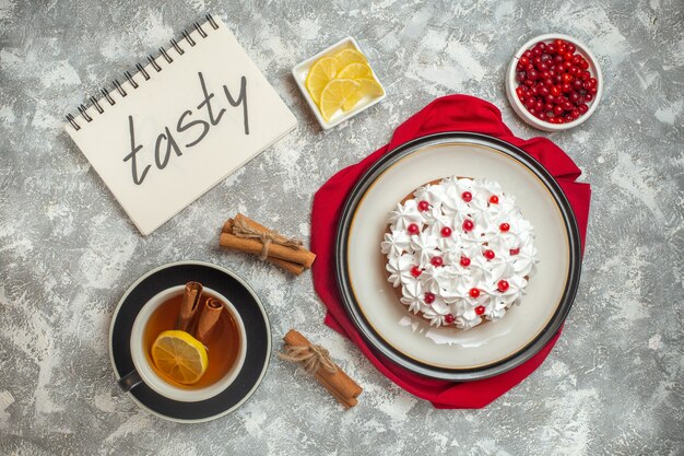 Draufsicht auf cremigen Kuchen mit Früchten auf rotem Tuch