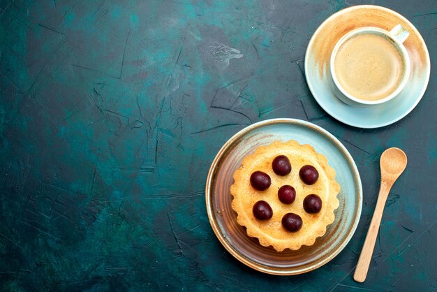 Draufsicht auf Cupcake mit frischen Kirschen neben schaumigem Latte