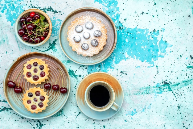 Draufsicht auf Cupcakes mit Sauerkirschen und heißem Americano