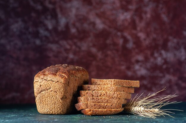 Draufsicht auf diätetische Schwarzbrotscheiben auf blaubraunem Mischfarbenhintergrund mit freiem Platz