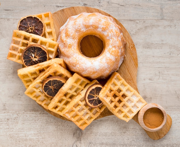 Kostenloses Foto draufsicht auf donuts mit waffeln und getrockneten zitrusfrüchten