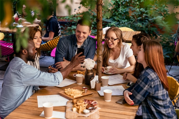 Draufsicht auf ein freundliches Treffen eines College-Studenten in ihrer Freizeit im gemütlichen Restaurant