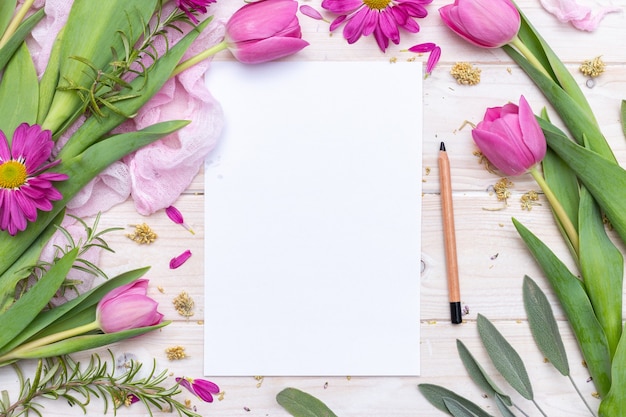 Draufsicht auf ein leeres Papier und einen mit lila Blumen verzierten Bleistift