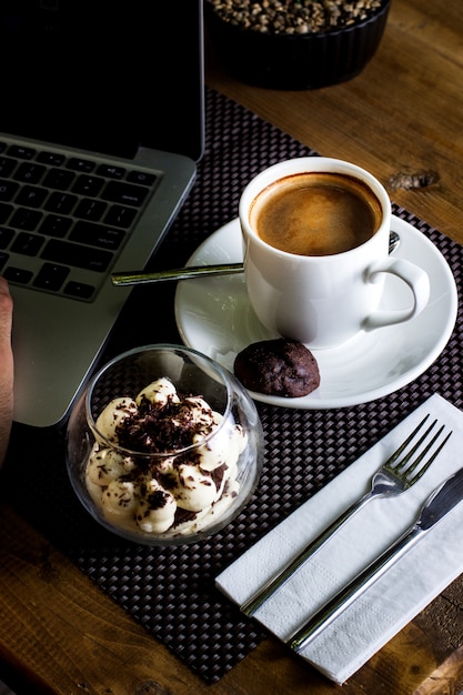 Draufsicht auf eine Glasschale Tiramisu und eine Tasse Espresso