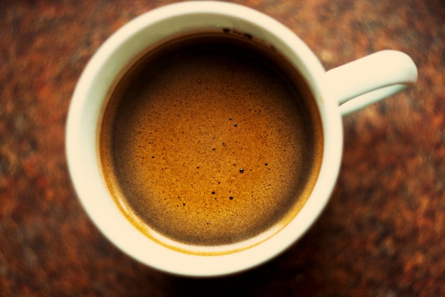 Draufsicht auf eine Tasse Kaffee auf einem Holztisch