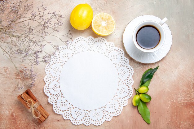 Draufsicht auf eine Tasse schwarzen Tee auf einer weiß dekorierten Serviette