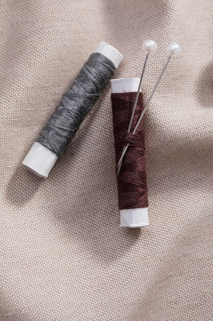 Draufsicht auf Fadenrollen mit Nadeln auf Textil