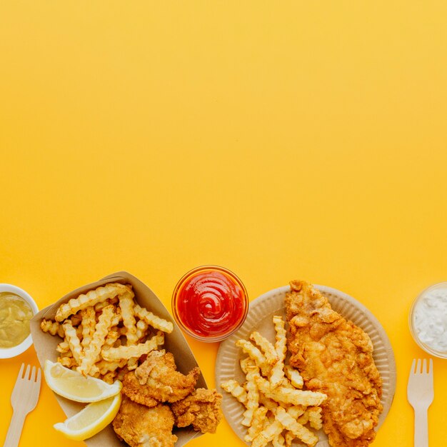 Draufsicht auf Fish and Chips mit verschiedenen Saucen und Kopierraum