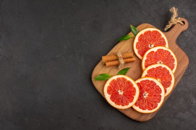 Draufsicht auf frische Grapefruitscheiben auf dunklem Hintergrund