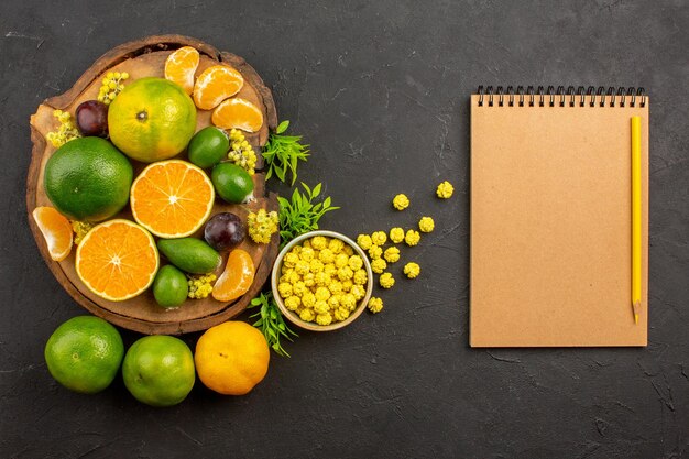 Draufsicht auf frische grüne Mandarinen mit Feijoas auf dunklem Tisch