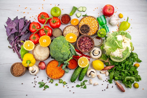 Draufsicht auf frische Lebensmittel und Gewürzgemüse zum Kochen auf weißem Tisch