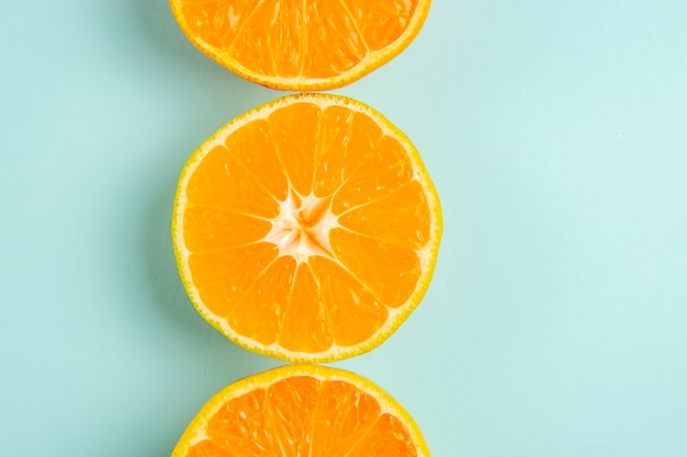 Draufsicht auf frische mandarinenscheiben auf hellblauem hintergrund Kostenlose Fotos